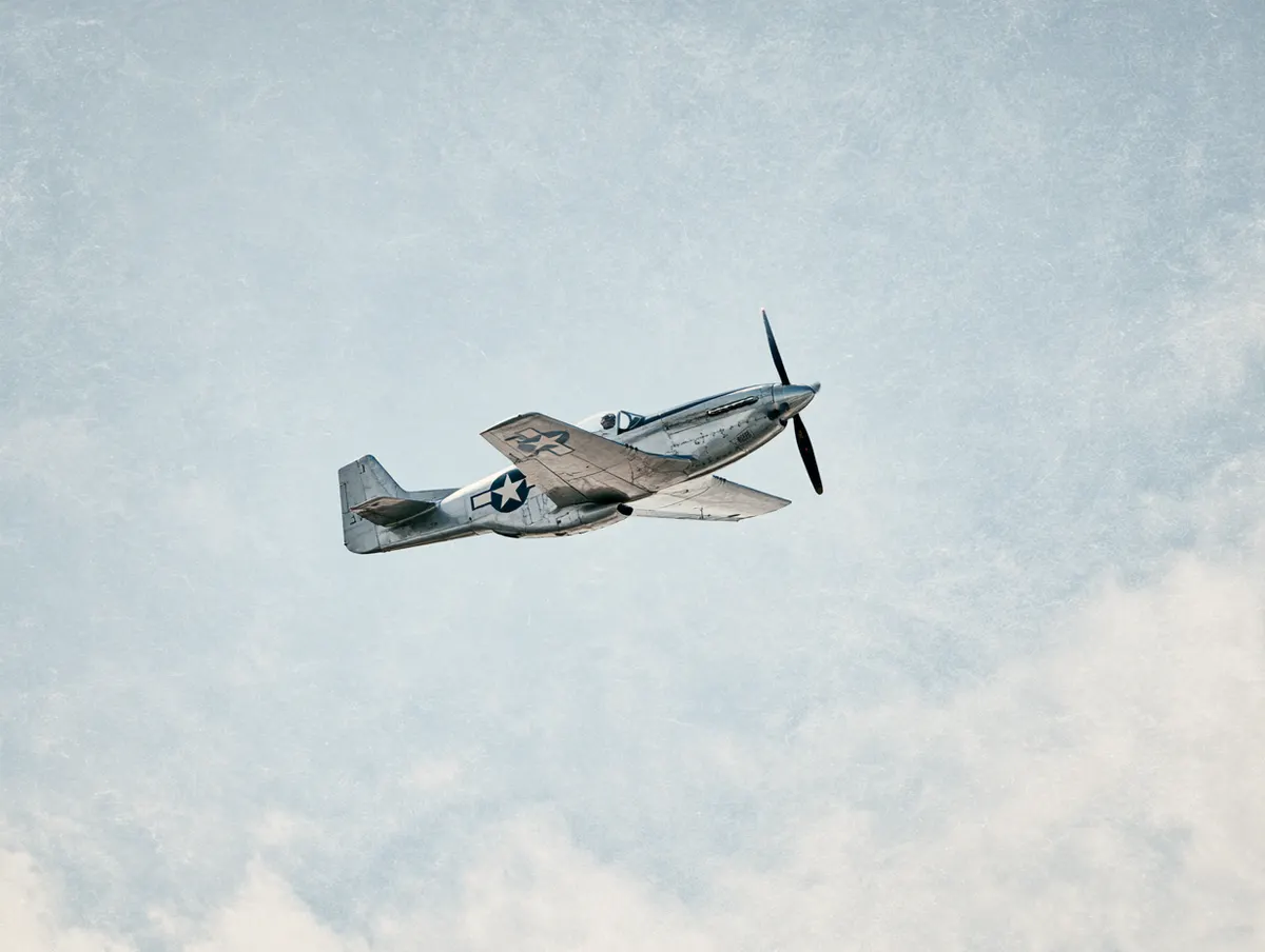 Vintage warbirds with contrails against a deep blue sky